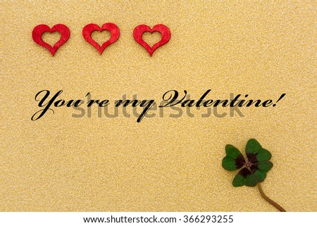 three hearts and a shamrock with text on a gold background