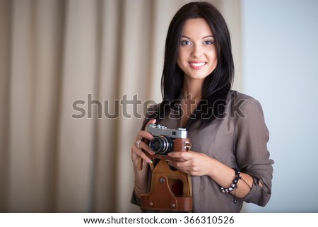 Young woman photographer processing pictures sitting on the desk