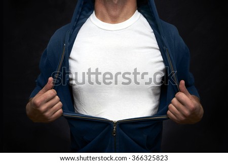 Hero pulling open blue blouse showing white t-shirt on blackboard background Royalty-Free Stock Photo #366325823