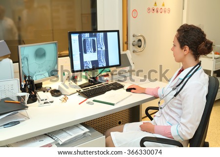 Experienced doctor looking at MRI scan of lumbar region on Monitor 