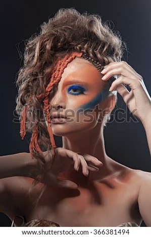 Art photo of a stressed ethnic woman with painted mask on face