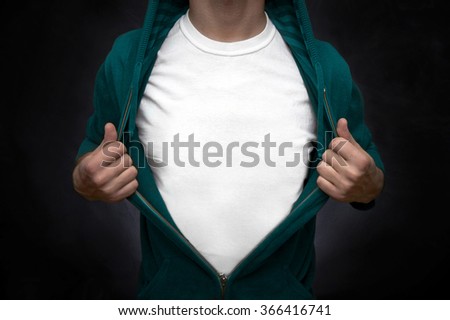 Hero pulling open turquoise blouse showing white t-shirt on blackboard background Royalty-Free Stock Photo #366416741