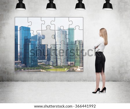 A businesswoman standing with arms crossed in front of a puzzle on the concrete wall with a picture of Singapore, one part missing, four lamps on the ceiling. Concept of getting the full picture.