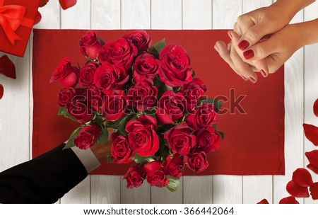 Man gives a woman a bouquet of roses for Valentines Day
