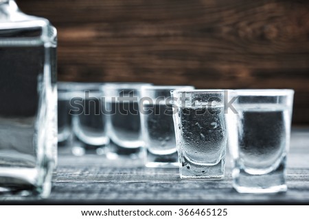  selectiv focus glasses of  cold vodka  on wooden table  Royalty-Free Stock Photo #366465125