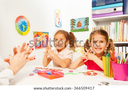 Two girls doing finger exercises as her teacher