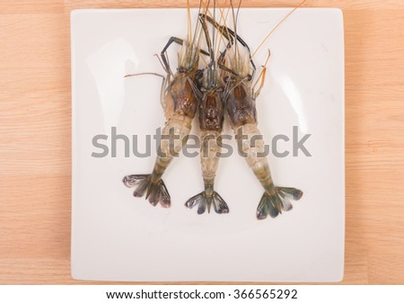 Raw tiger Fresh shrimps on white dish with wooden table