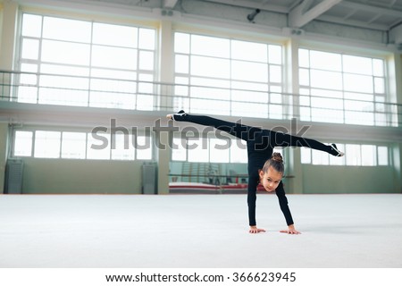 little gymnast standing on hand doing the splits