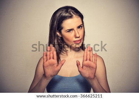Closeup portrait young annoyed angry woman with bad attitude gesturing with palms outward to stop isolated on grey wall background. Negative human emotion face expression feeling body language Royalty-Free Stock Photo #366625211