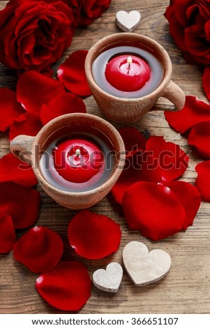 Floating candles in water among rose petals. Aromatherapy in spa.
