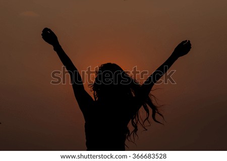 woman successfull and very happy open arms under the sunset
