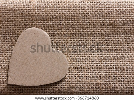 heart symbol cut out from packaging cardboard on hempen cloth. Copy space. Free space for text, Close-up, top view