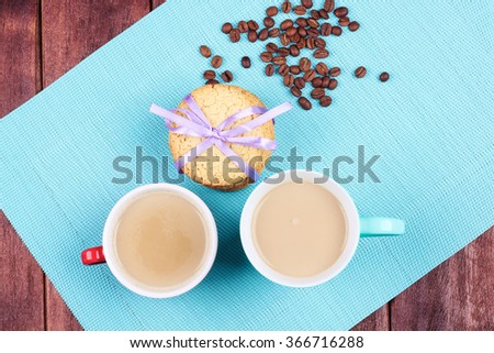 Two cups of coffee on the table. Morning coffee for two with cookies and coffee beans on the Valentines Day.