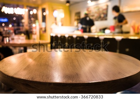 Empty wood table top with blur of  coffee shop or cafe restaurant background.For montage product display/ selective focus