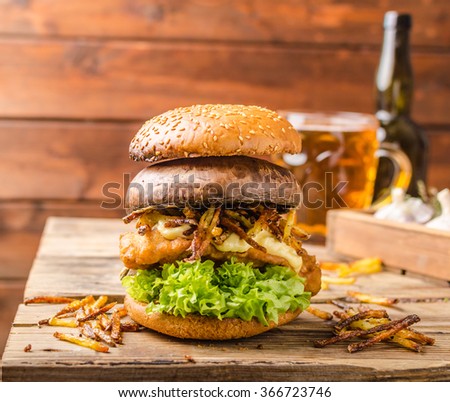 Fish and Chips Burger with fried potato straw and grilled portobello, fresh salad and cold beer