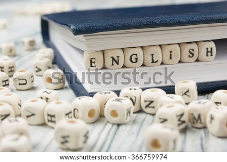 Word english made with block wood letters next to a pile of other letter over  wooden table Royalty-Free Stock Photo #366759974