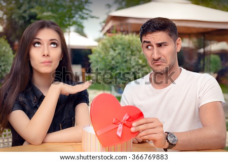 Girl Refusing Heart Shaped Gift From Her Boyfriend - Materialist girlfriend refusing a present from her loved one
 Royalty-Free Stock Photo #366769883
