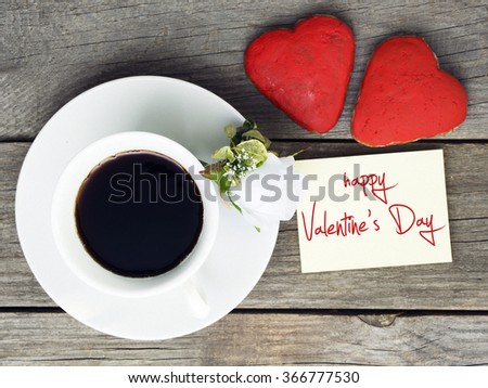Romantic breakfast on Valentine's Day. Cup of coffee and heart shape cookies, white rose decoration, Happy Valentine's Day message. Toned image