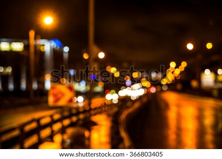 Rainy night in the big city, cars driving on highway. Defocused image