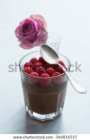 Homemade chocolate mousse without eggs with raspberries and blueberries, served in a glass or in espresso cups. Natural light. Selective focus. 
