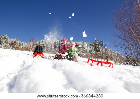 Happy children sledding at winter time. Group of children spending a nice time in winter.