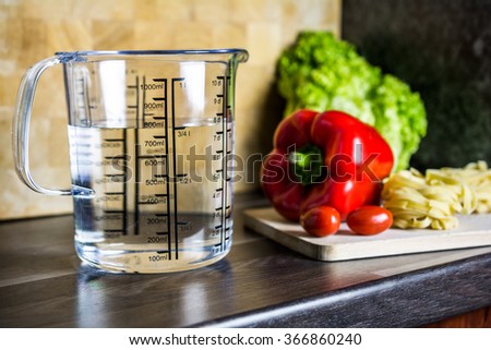 750ccm / 3/4 Liter / 750ml Of Water In A Measuring Cup On A Kitchen Counter With Food Royalty-Free Stock Photo #366860240