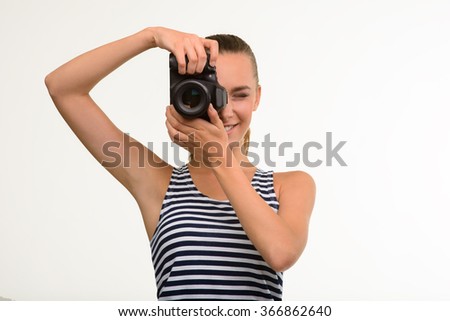 Pretty girl making photo. Nice girl with camera. Paparazzi making photo using professional camera.