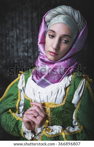 Medieval woman holding hands in prayer Pray. In the old beautiful yellow-green dress. Historic image. Gothic. Europe