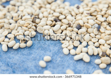 un-roasted coffee beans heap with shallow depth of field