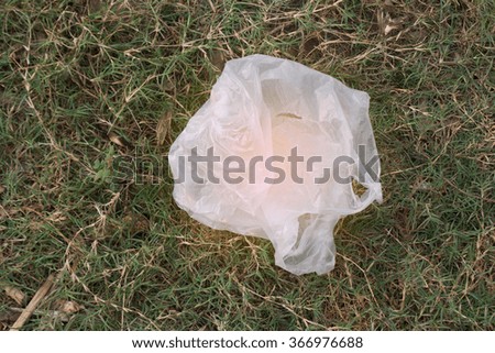 Plastic garbage bags lay on the grass green.
