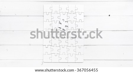 white completed puzzle with one undone piece