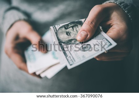 Hands holding russian rouble and us dollar bills. Toned picture