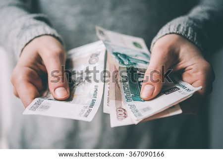 Hands holding russian rouble bills. Toned picture