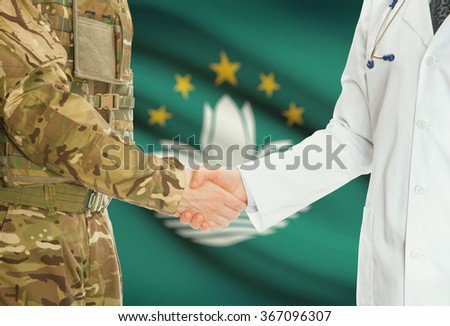 Soldier in uniform and doctor shaking hands with national flag on background - Macau