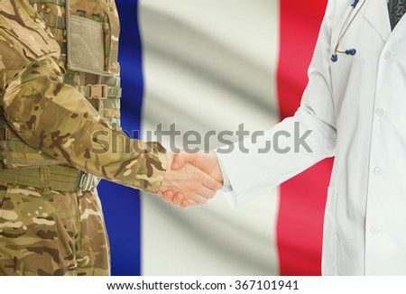 Soldier in uniform and doctor shaking hands with national flag on background - France