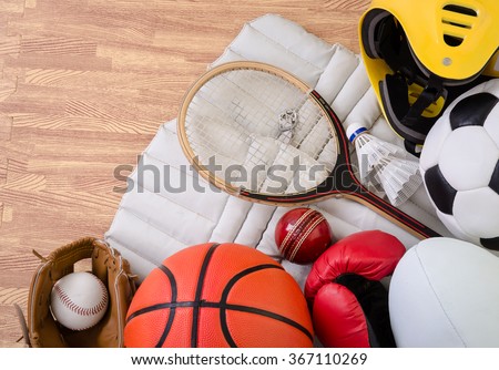 sports equipment on a gym floor, football, rugby, baseball, cricket, basketball, boxing, badminton and squash.  Royalty-Free Stock Photo #367110269