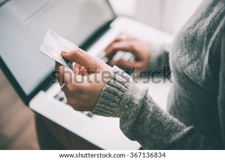 Hands holding plastic credit card and using laptop. Online shopping concept. Toned picture Royalty-Free Stock Photo #367136834