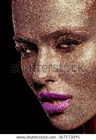 Beautiful, amazing portrait of woman. Unreal make up like a space. Closeup shooting in studio with black background. Emotion, posing of model. Gold, pink glitter.
