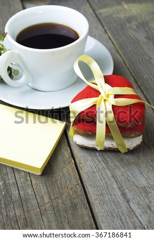 Romantic breakfast on Valentine's Day. Cup of coffee and heart shape cookies, white rose decoration, sticker for text. Toned image