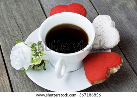 Romantic breakfast on Valentine's Day. Cup of coffee and heart shape cookies, white rose decoration. Toned image