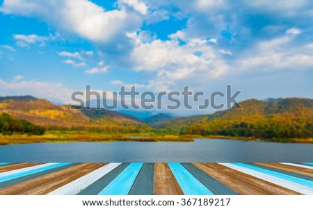 Wood pier or walkway or an old wooden table with blur image of lake in background