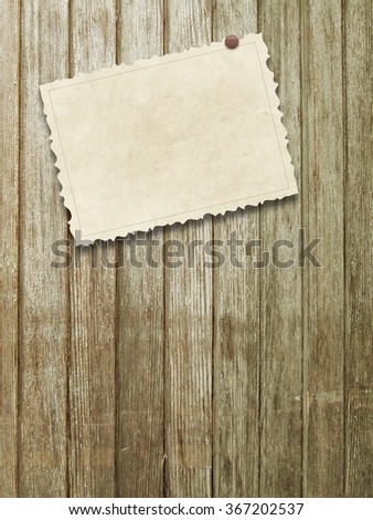 Close-up of one old vintage postcard with red pin on vertical brown wooden boards background