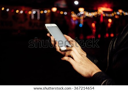 Cropped image of female hands holding mobile cell phone with blank copy space screen on a bokeh background