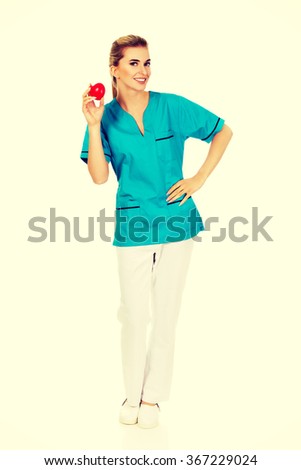 Smiling nurse or female doctor with heart