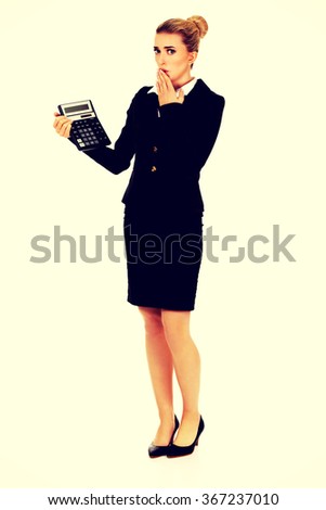Shocked businesswoman looking at calculator