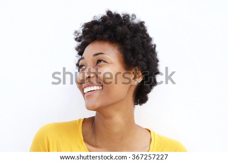 Closeup portrait of happy young african woman looking away against white background
