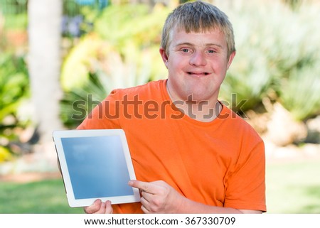 Close up outdoor portrait of Young handicapped man pointing at blank tablet screen. Royalty-Free Stock Photo #367330709