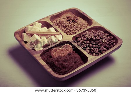 Different kinds of coffee on wooden plate on blue table. Toned.