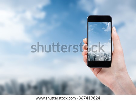 woman hand taking photo of the city with a smartphone