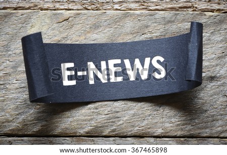 paper sheet with e-news text on wooden background